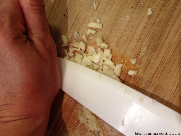Epluchez et détaillées en petits cubes une gousse d'aille. Terminez le travail en écrasant l'ail avec la lame du couteau, côté "plat". 