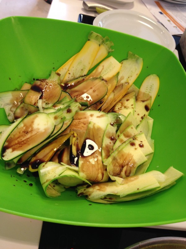 Colorez vos lamelles crues de courgettes avec un peu de vinaigre balsamique. Mélangez bien le tout avec les doigts.